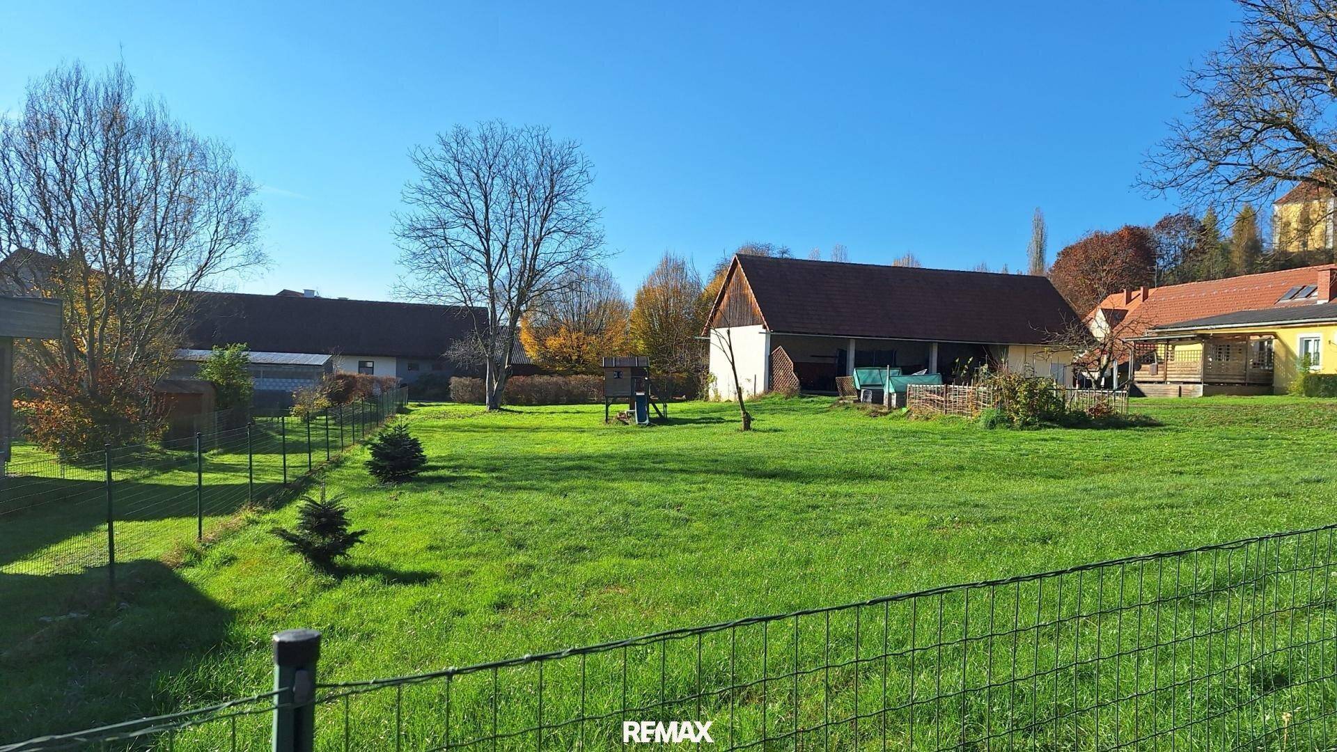 Weitläufiges Grundstück mit gelbem Haus, Scheune und kahlen Bäumen in ländlicher Umgebung.