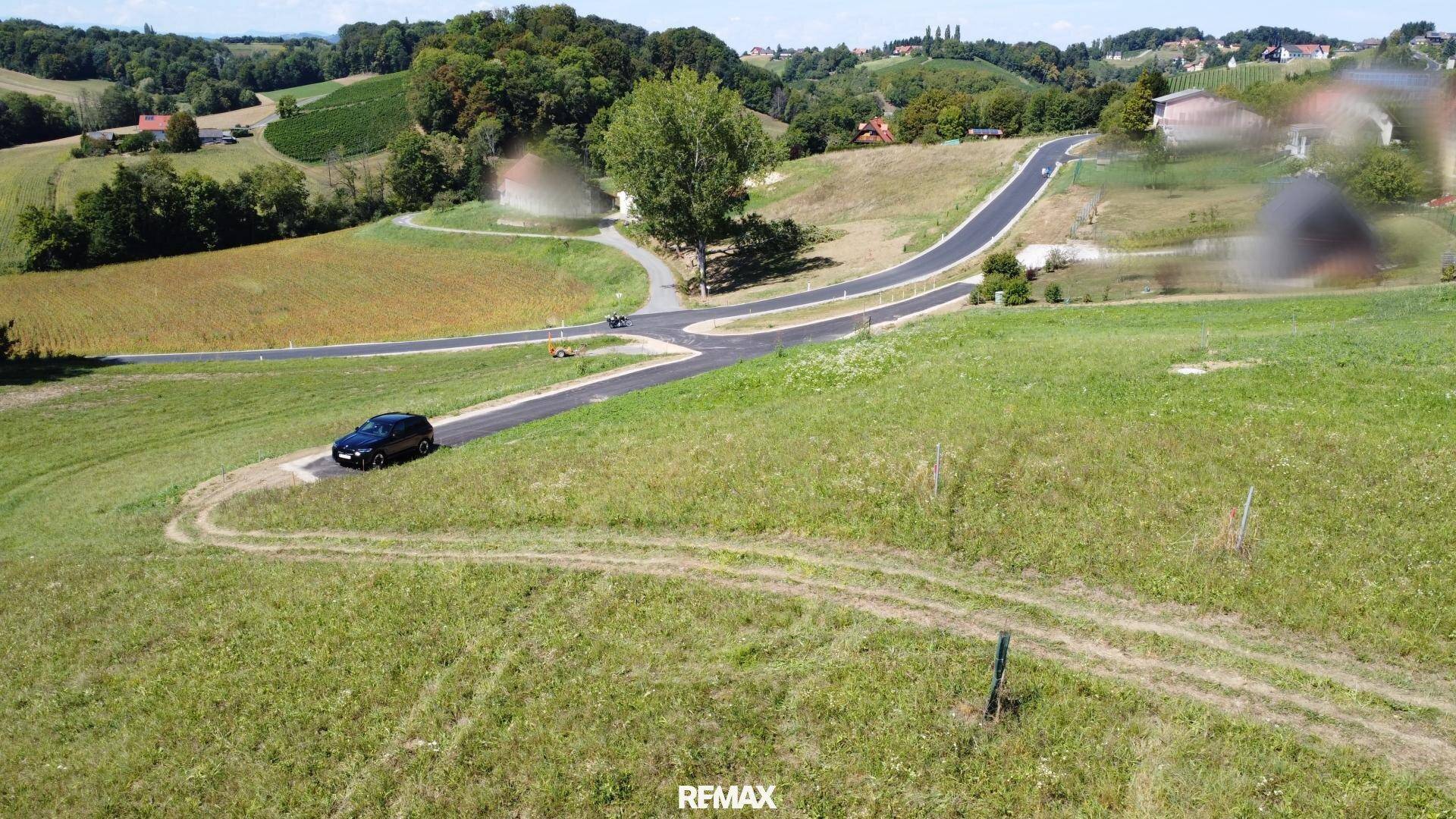 Luftaufnahme eines weitläufigen Grundstücks mit Zufahrtsstraße und ländlicher Umgebung.