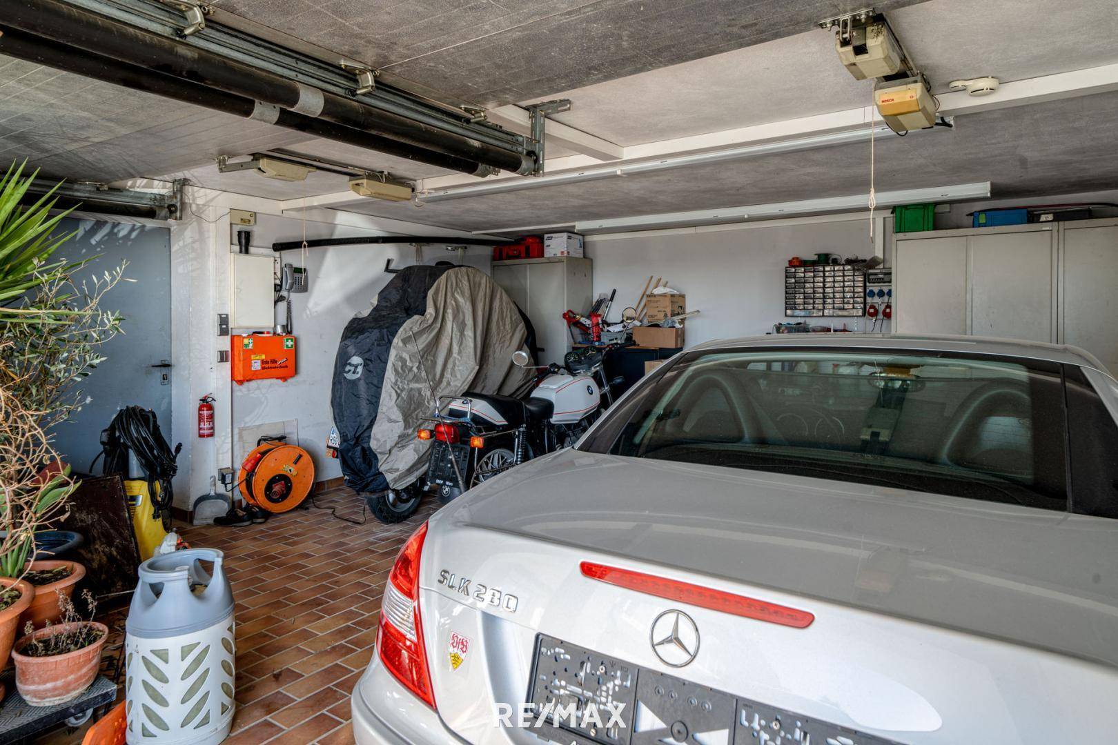 Geräumige Garage mit Platz für Fahrzeuge und zusätzlichem Stauraum.