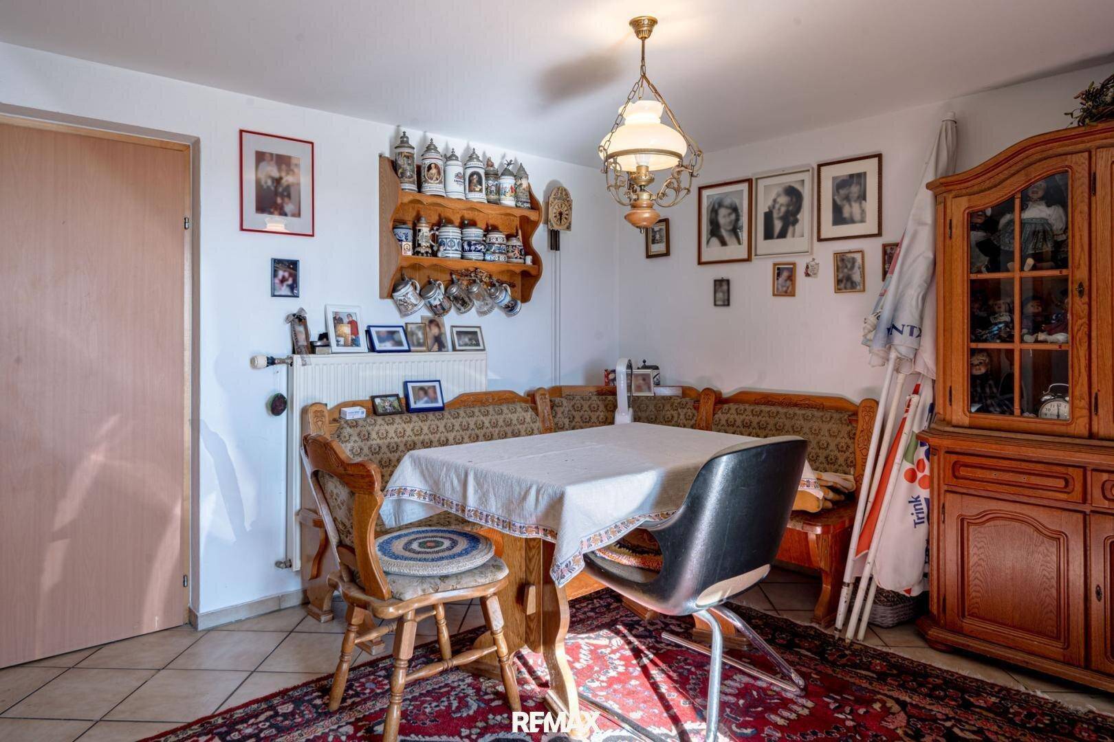 Gemütlicher Essbereich mit Eckbank, Esstisch und traditionellem Holzschrank, gefliester Boden.