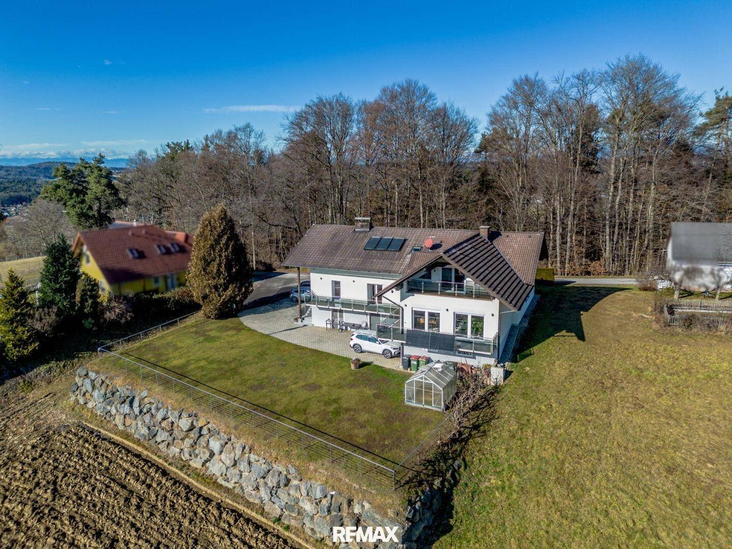 Luftaufnahme des Anwesens mit großem Garten, umgeben von Feldern und Wald.