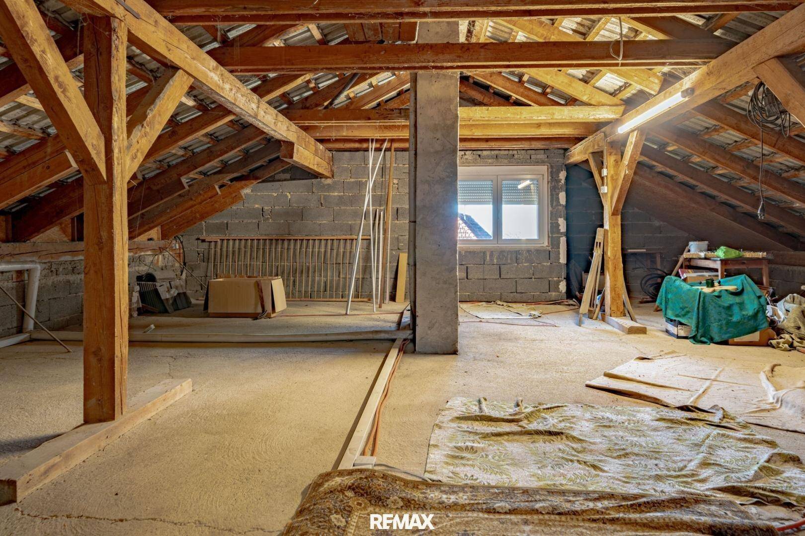 Unausgebauter Dachboden mit sichtbaren Holzbalken und viel Stauraum.