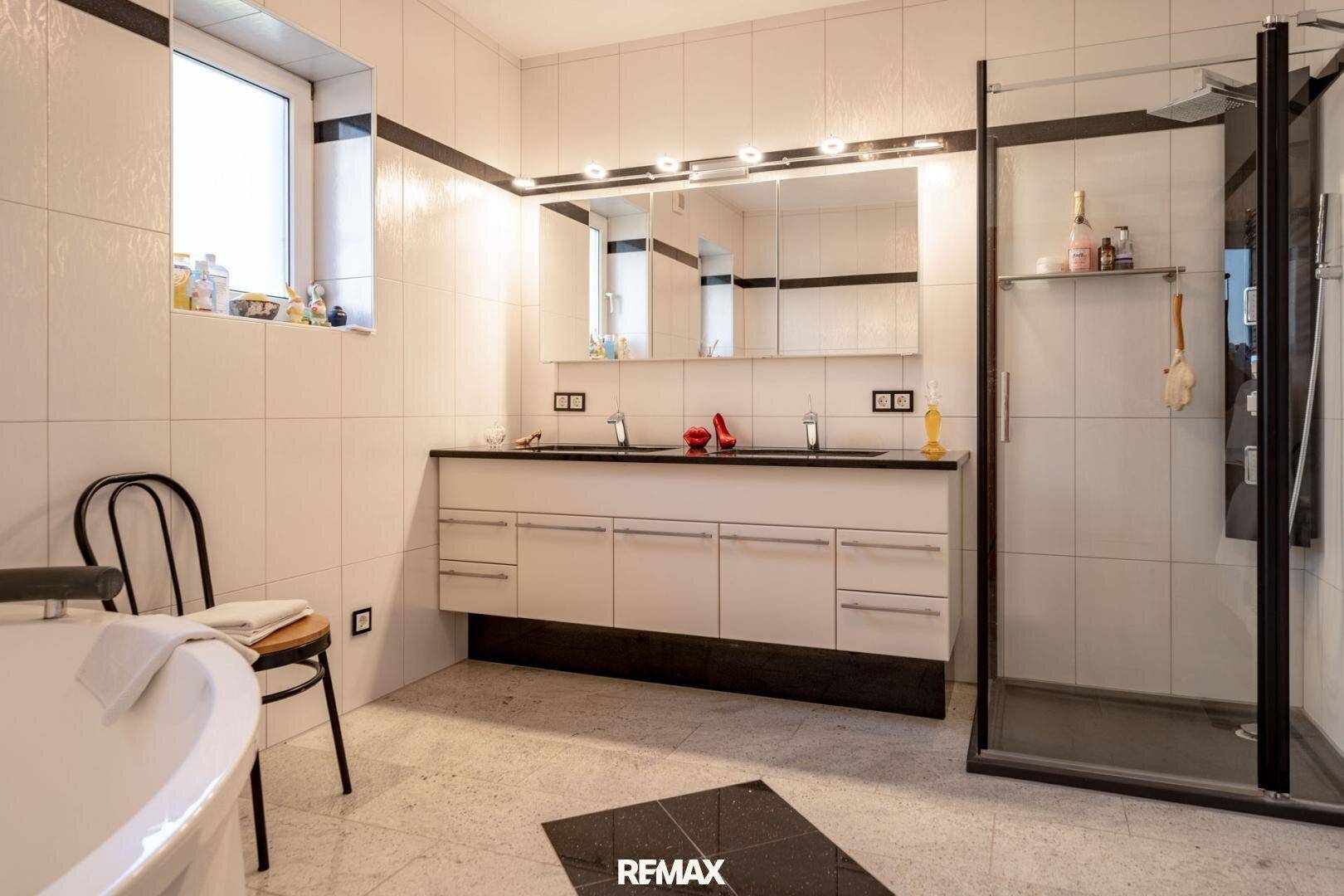 Großes Badezimmer mit Doppelwaschbecken, Whirlpool und separater Duschkabine.