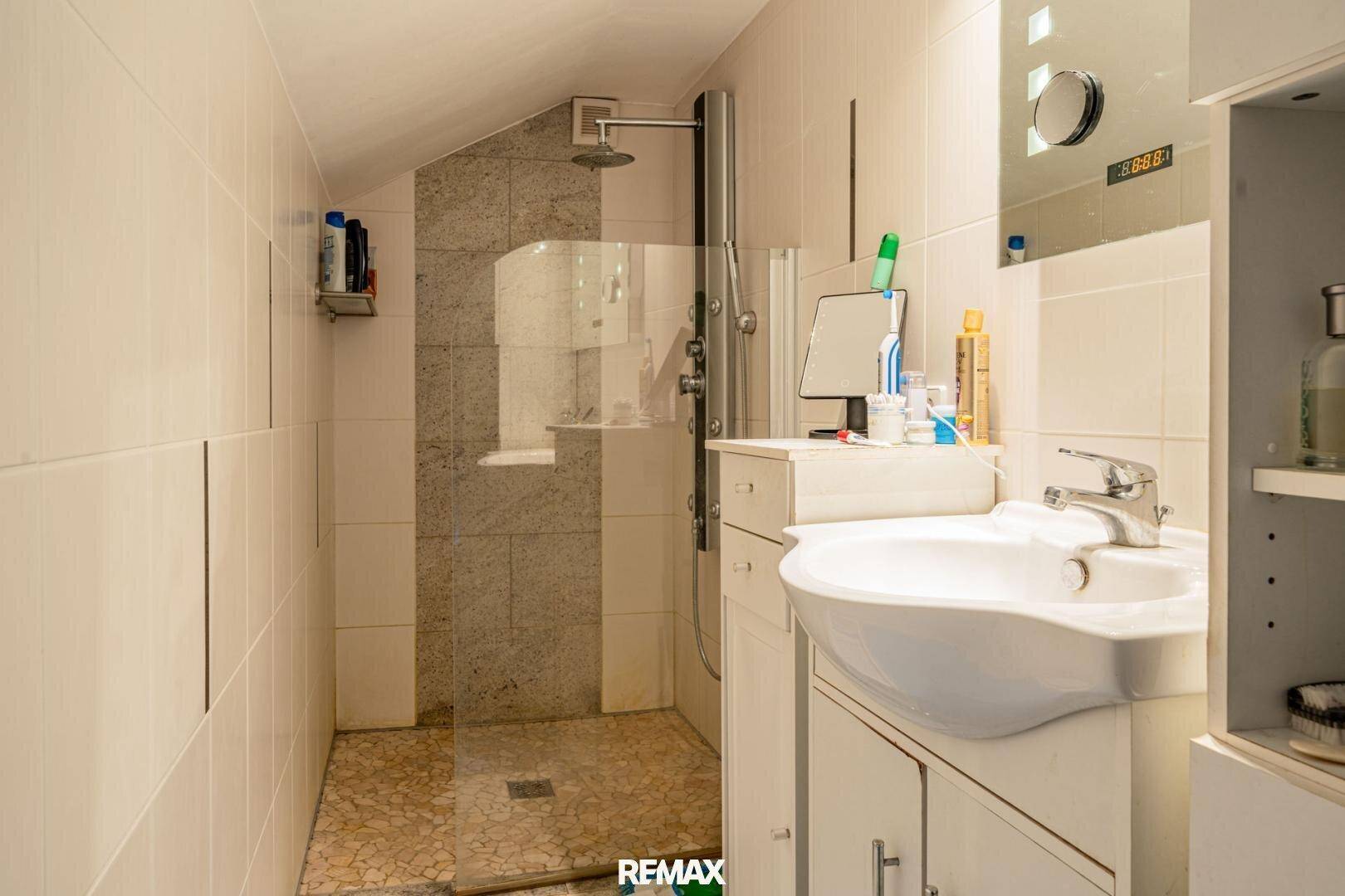 Modernes Duschbad im Dachgeschoss mit begehbarer Dusche und Waschbecken.