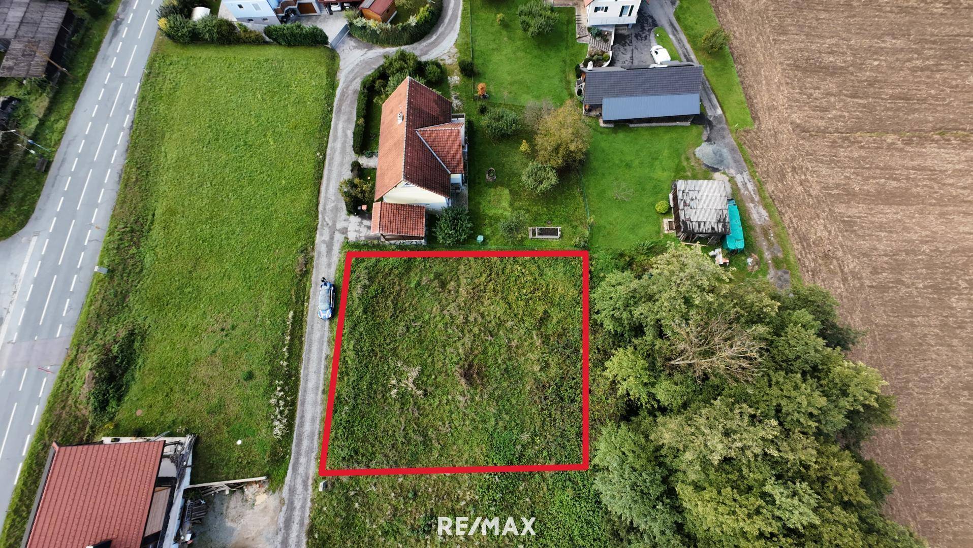 Luftaufnahme eines Grundstücks, markiert mit einem roten Rahmen, umgeben von Häusern und Feldern.