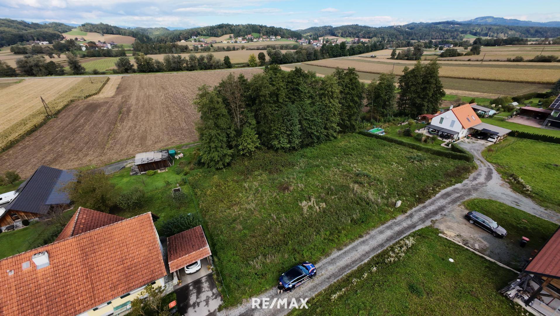 Luftaufnahme eines Grundstücks mit umliegenden Häusern, Feldern und einer ländlichen Straße.