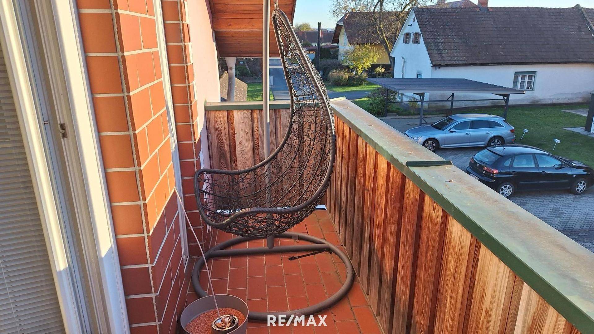 Gemütlicher Balkon mit Hängesessel und Blick auf die Umgebung, ideal zum Entspannen.