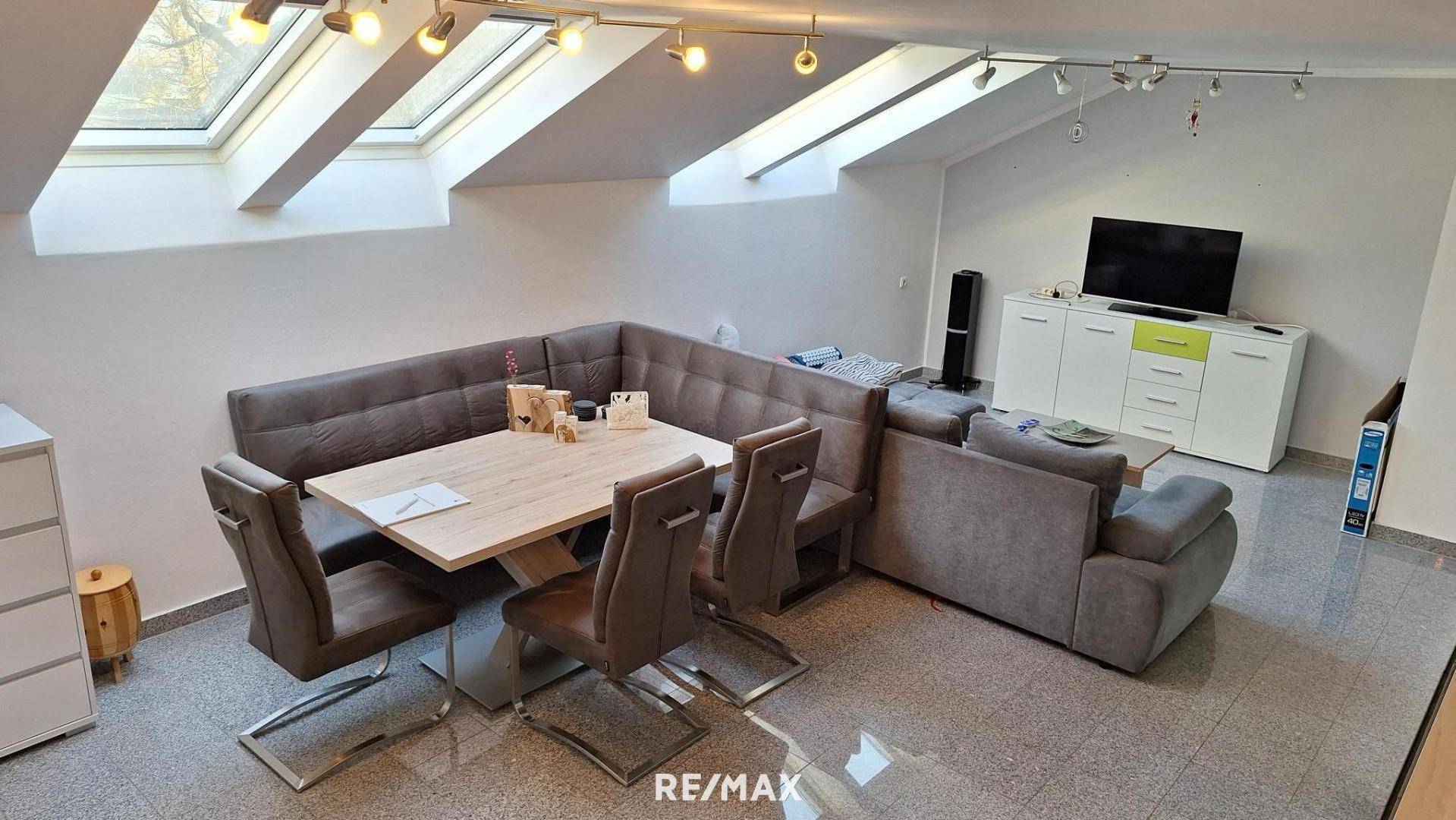 Geräumiger Wohn- und Essbereich im Dachgeschoss mit viel Tageslicht durch die Dachfenster.