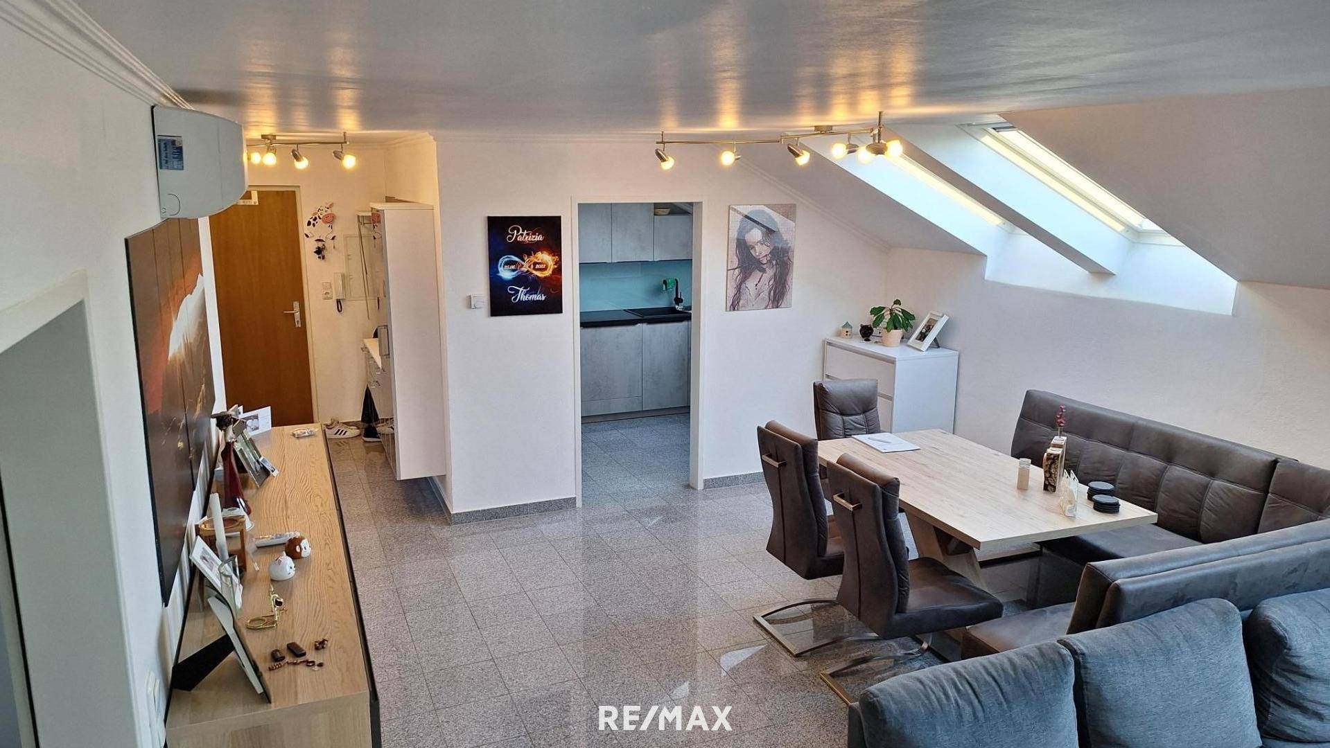 Offener Wohn-Essbereich mit integrierter Küche, gemütlicher Sitzecke und Dachfenstern für viel Licht.