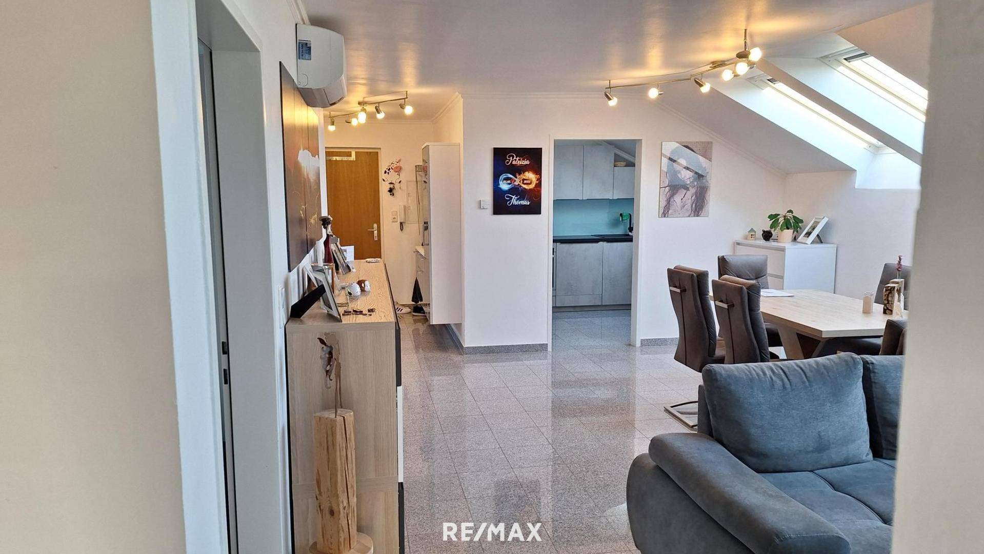 Heller Wohn-Essbereich mit offener Küche, gemütlicher Sitzecke und Dachfenstern im Dachgeschoss.