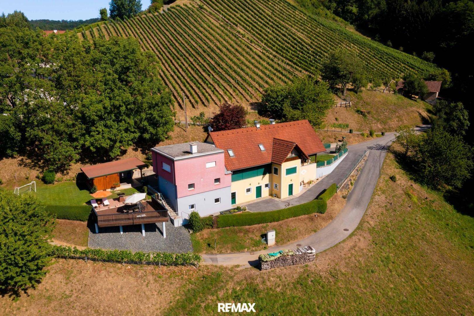 Luftaufnahme des Anwesens mit mehreren Gebäuden, umgeben von Weinbergen und Natur.