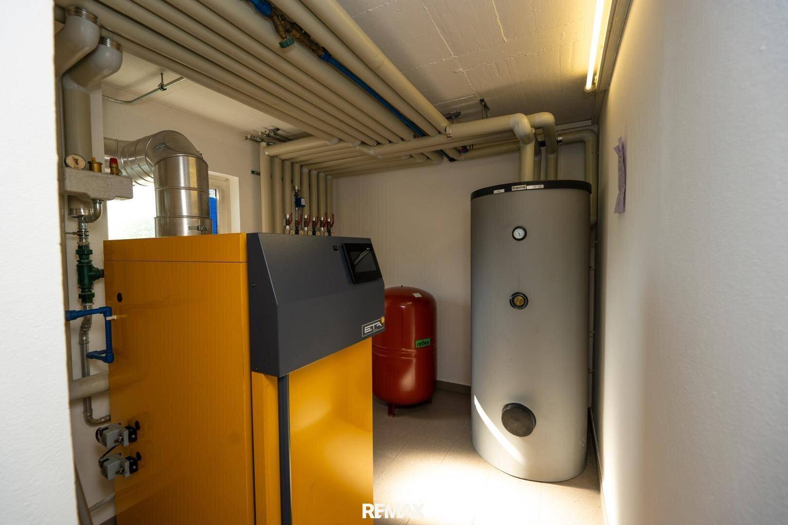 Heizungsraum mit modernem Heizkessel und Warmwasserspeicher.