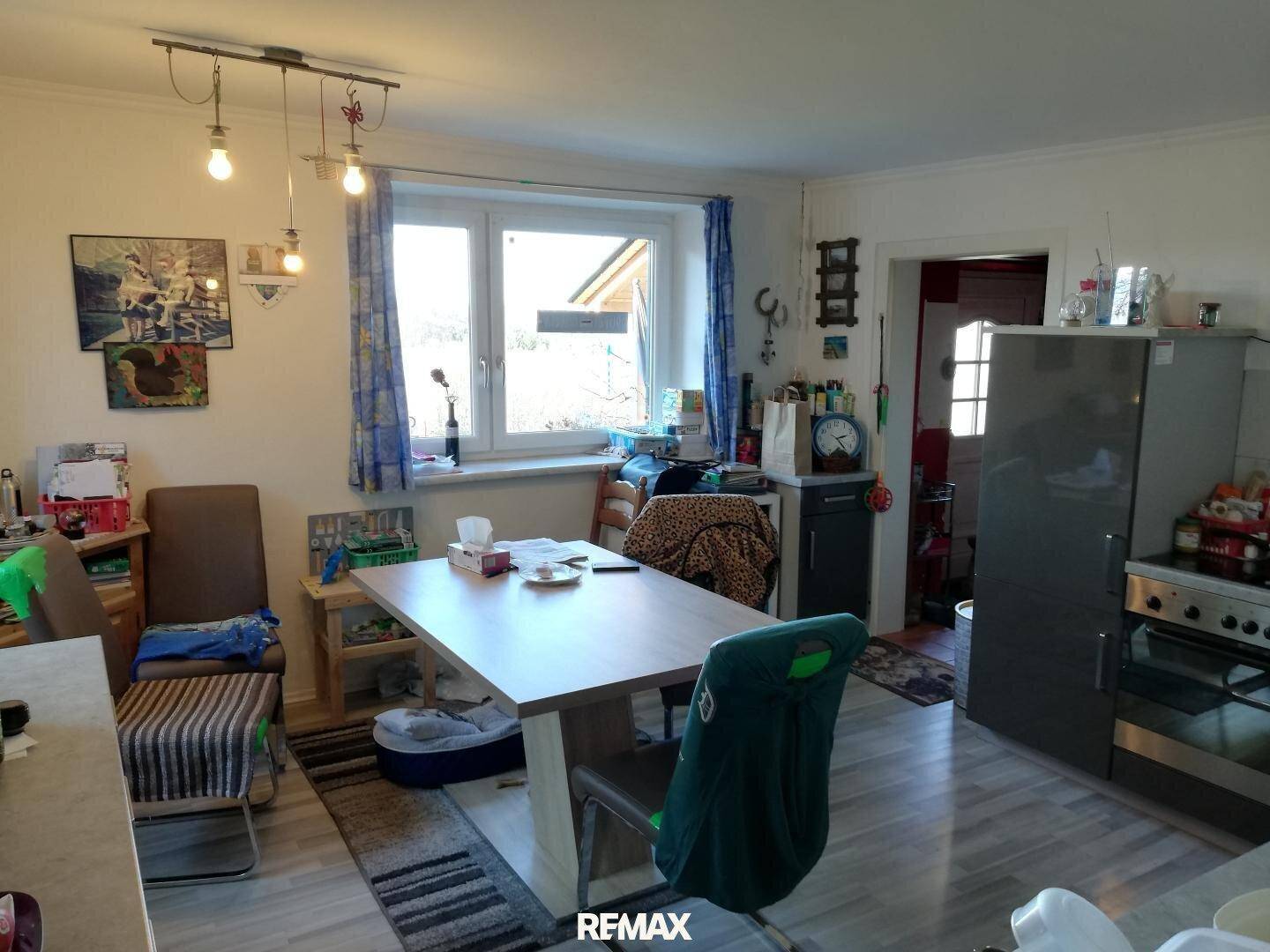 Heller Essbereich mit Holztisch, Stühlen und einem Fenster mit Blick nach draußen.
