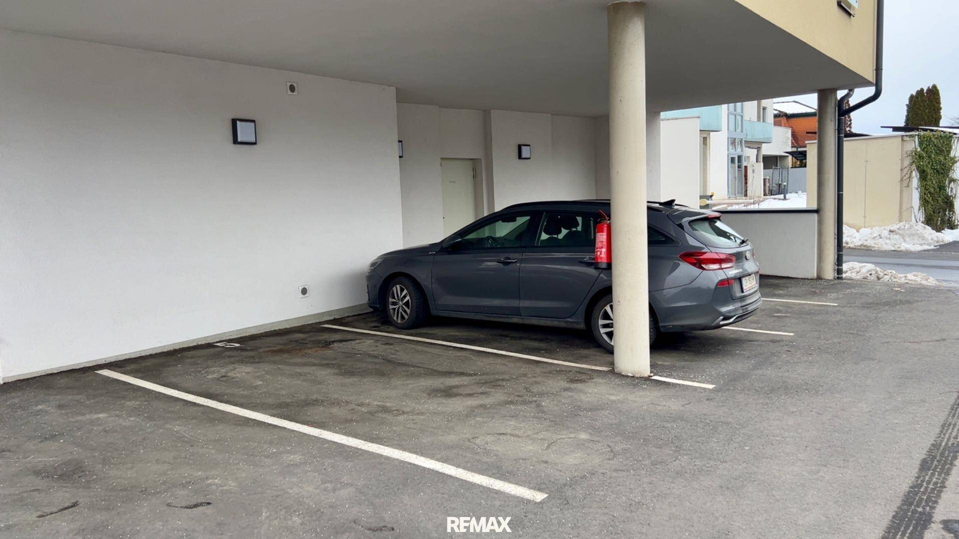 Überdachter Außenstellplatz für ein Fahrzeug unter einem Carport, mit ausreichend Platz.