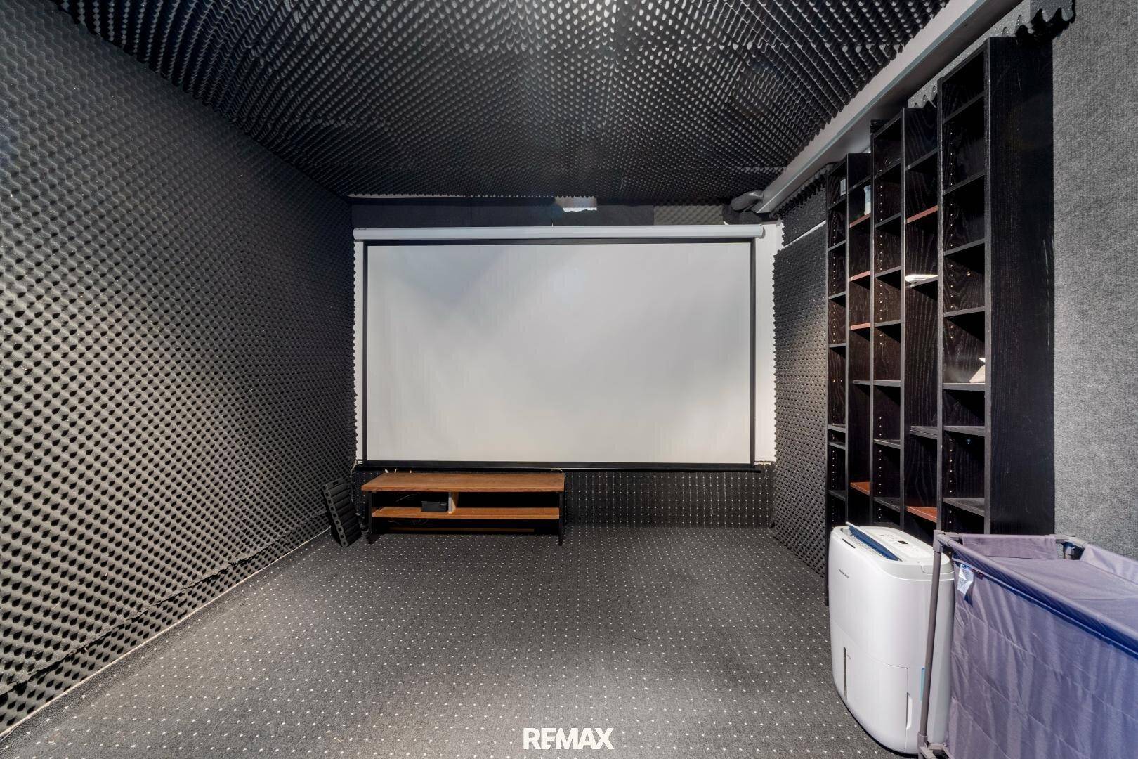 Heimkino mit großer Leinwand und schallabsorbierenden Wänden, ideal für Filmabende.