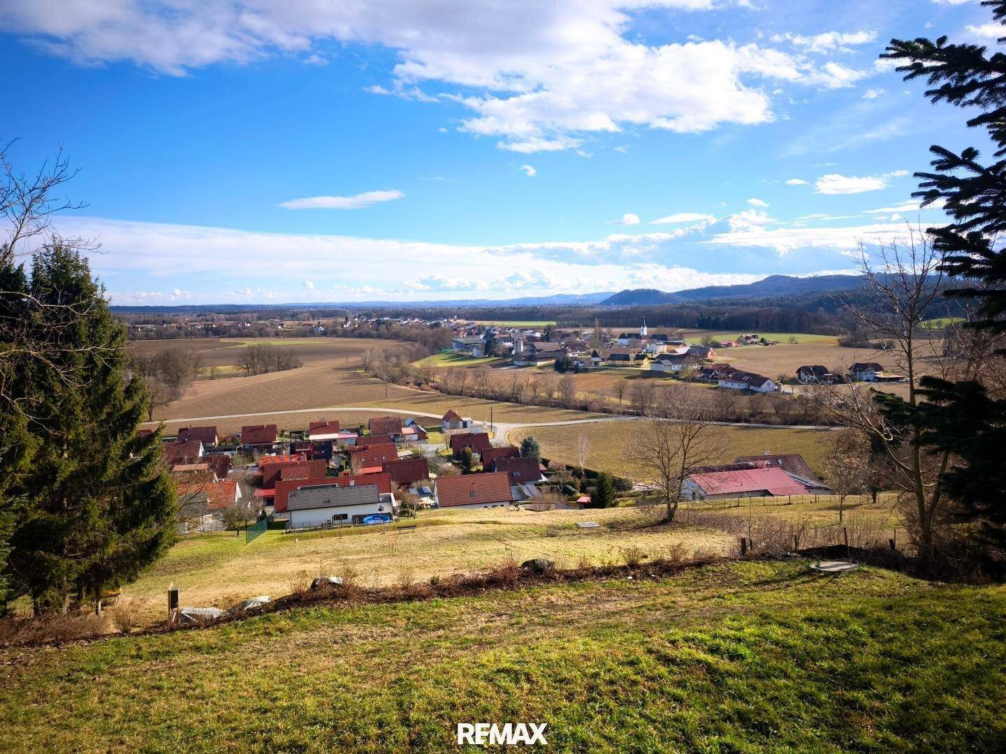 Weitläufiger Blick über die ländliche Umgebung mit kleinen Dörfern unter blauem Himmel.