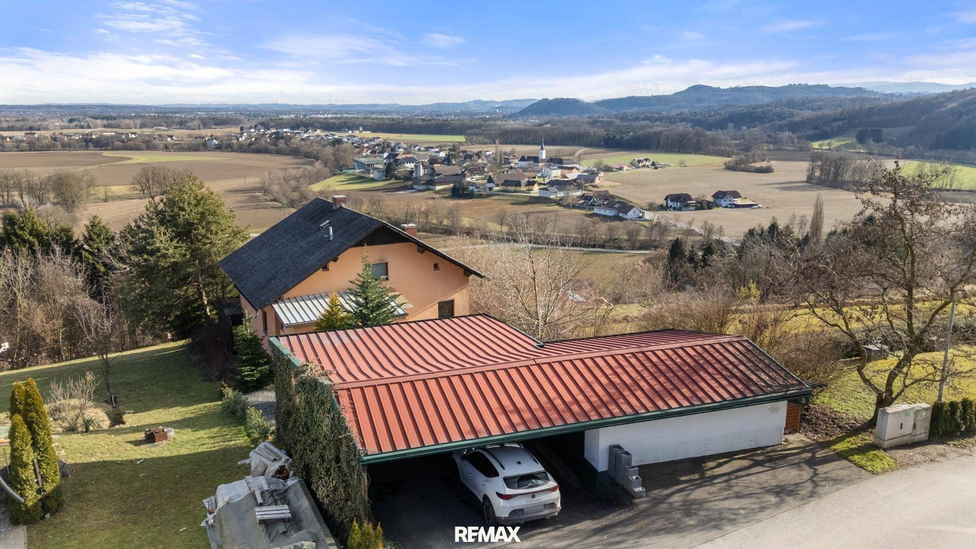 Luftaufnahme eines Hauses mit großem Carport und weitem Blick über die Landschaft.