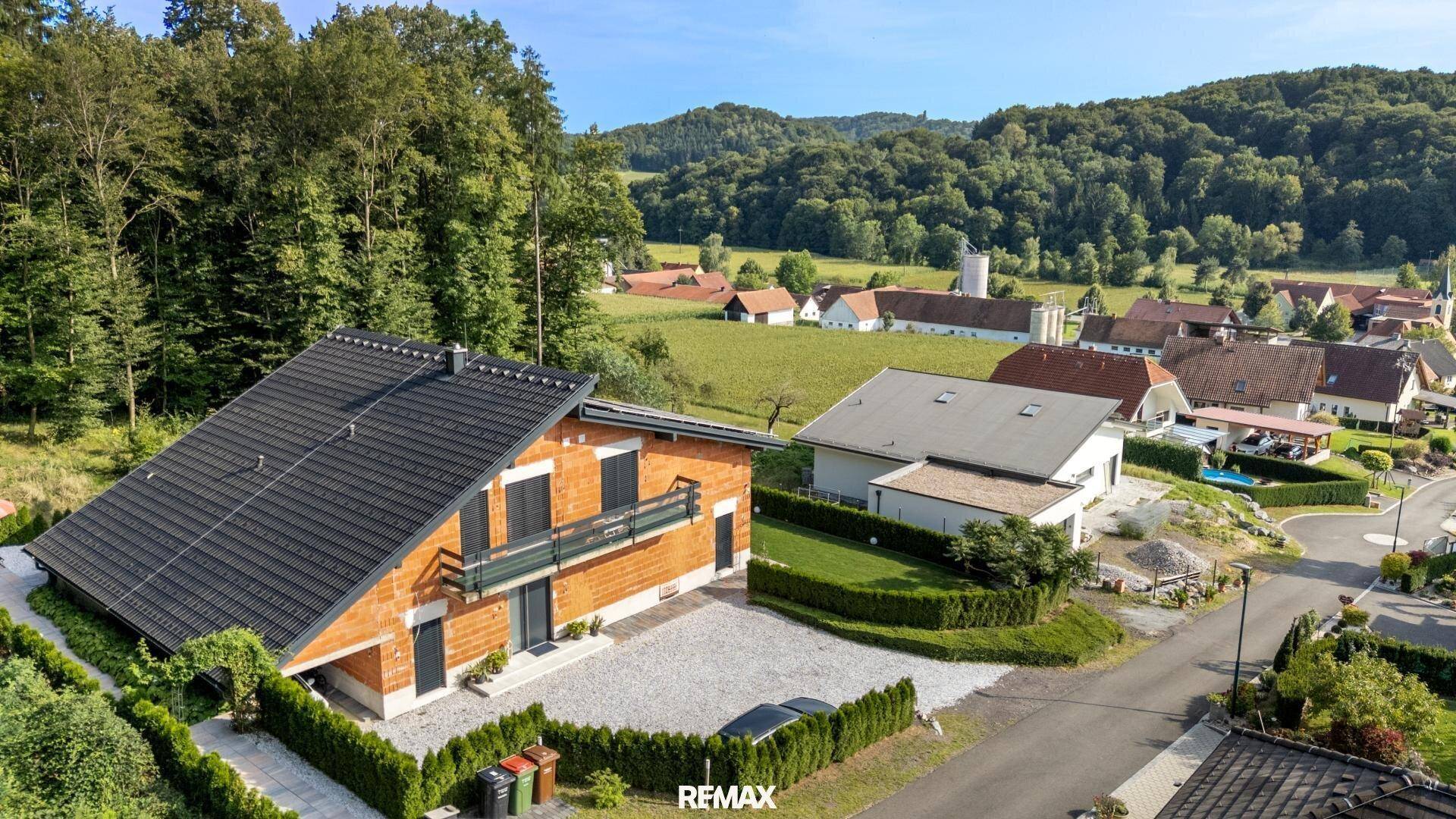 Übersicht des Hauses in ländlicher Umgebung mit weiteren Wohnhäusern und viel Grünfläche.