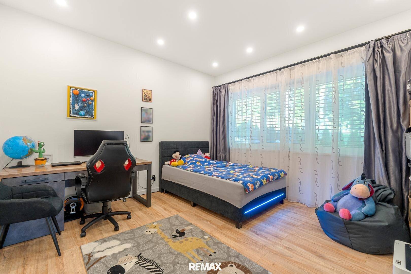 Kinderzimmer mit Einzelbett, Schreibtisch und Blick ins Grüne.