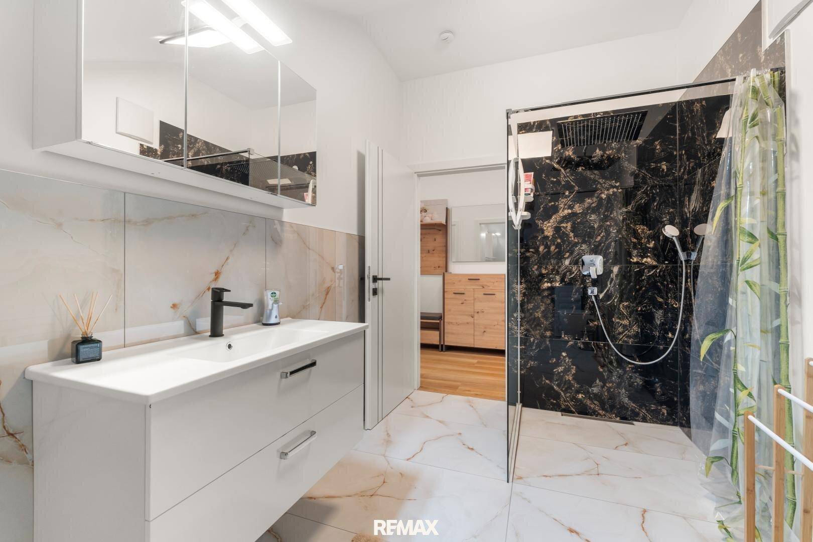 Modernes Badezimmer im Dachgeschoss mit Dusche und eleganten Marmorfliesen.