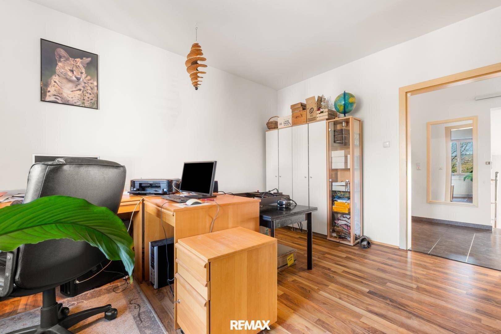 Helles Arbeitszimmer mit Holzboden, Schreibtisch und Stauraum, ideal für Home-Office.