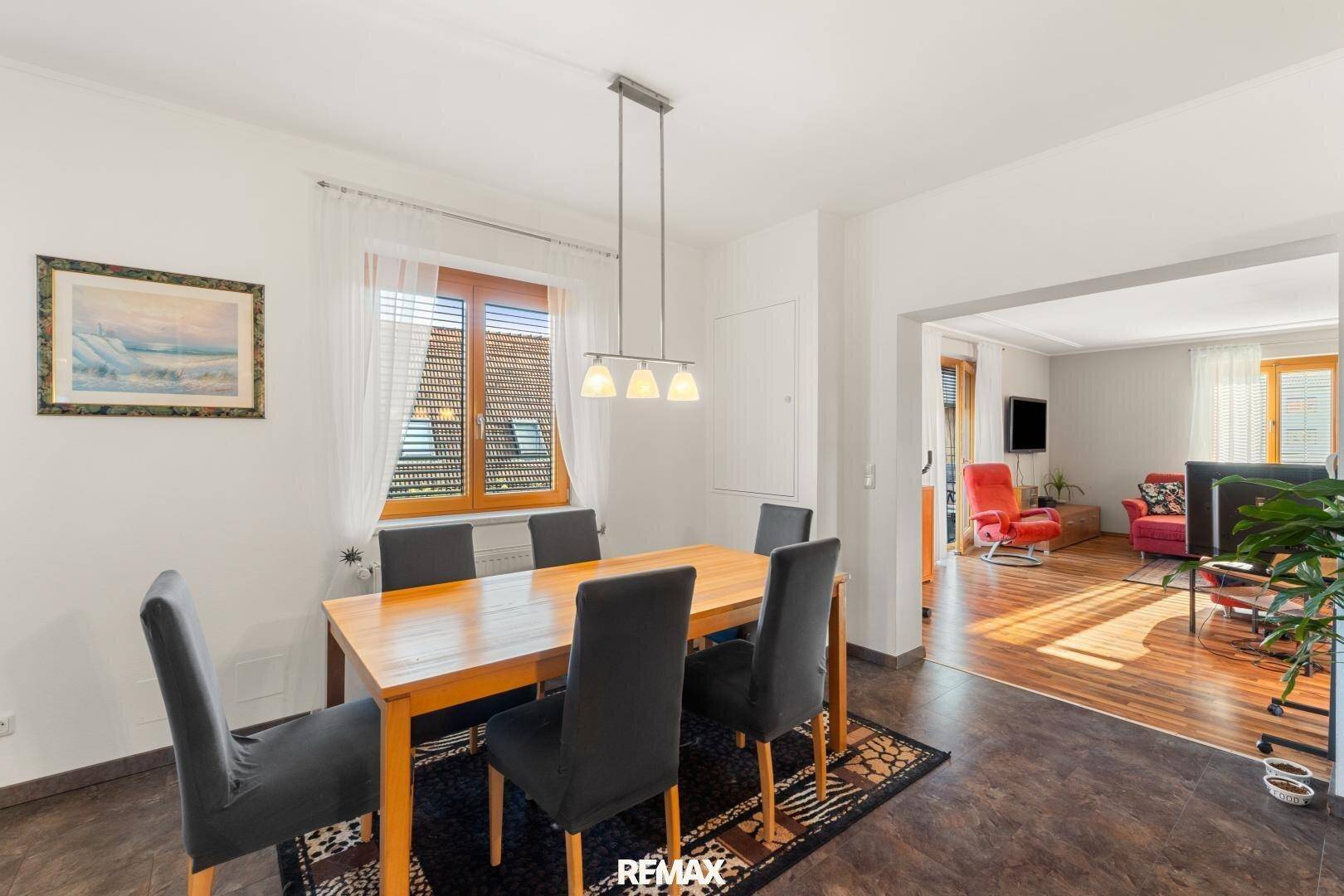 Essbereich mit Holztisch und Zugang zum Wohnzimmer, ideal für gesellige Abende.