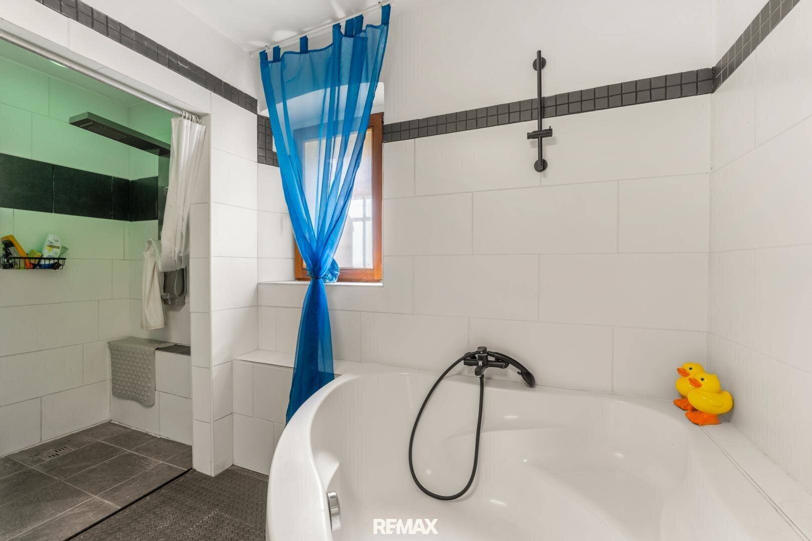 Modernes Badezimmer mit begehbarer Dusche und Badewanne für entspannende Momente.