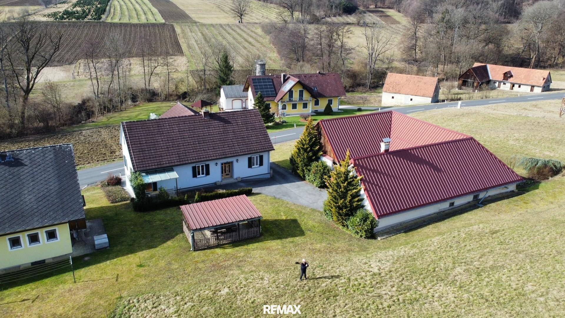 Luftaufnahme des Anwesens mit Haupthaus, Nebengebäude und weitläufiger ländlicher Umgebung.