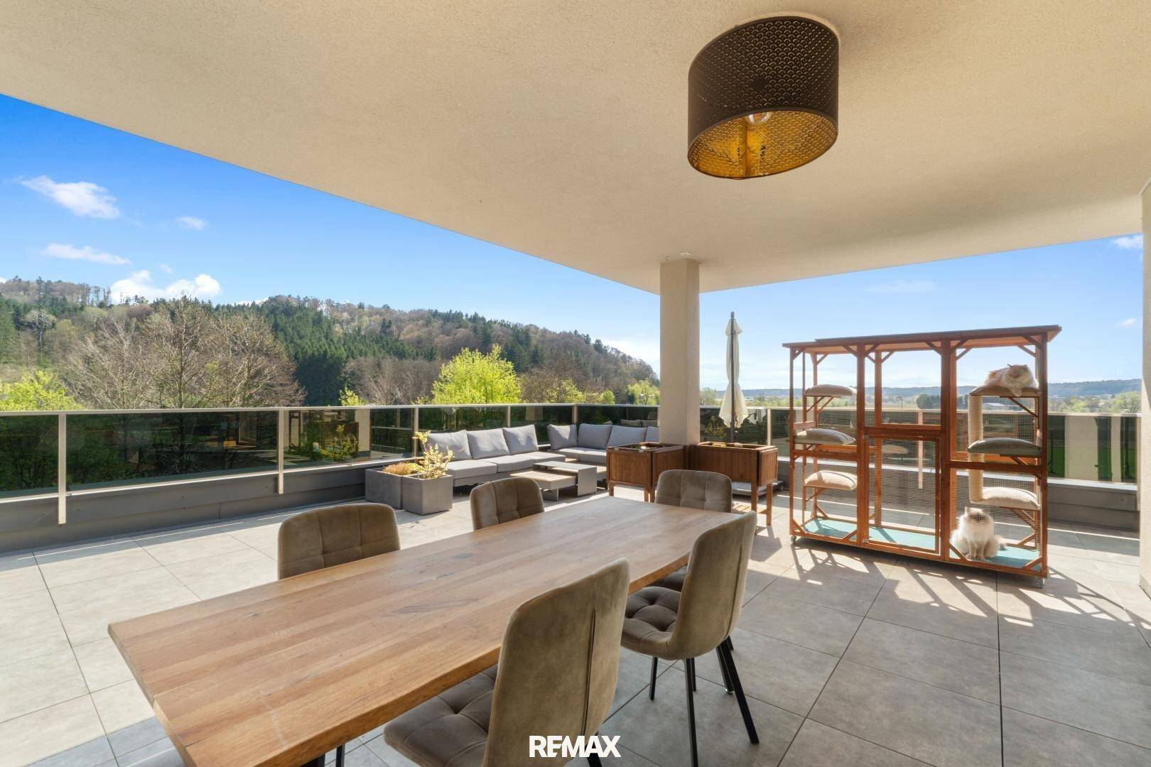 Weitläufige Dachterrasse mit Essbereich, Lounge-Möbeln und Panoramablick.