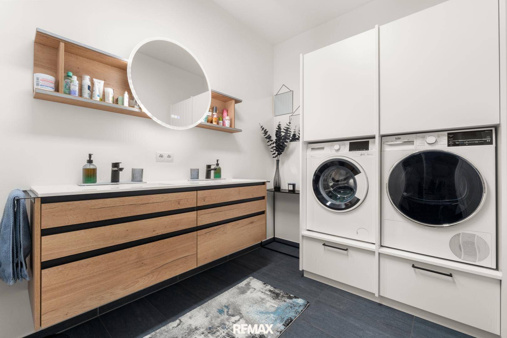 Geräumiges Badezimmer mit Doppelwaschbecken, Waschmaschine und Trockner.