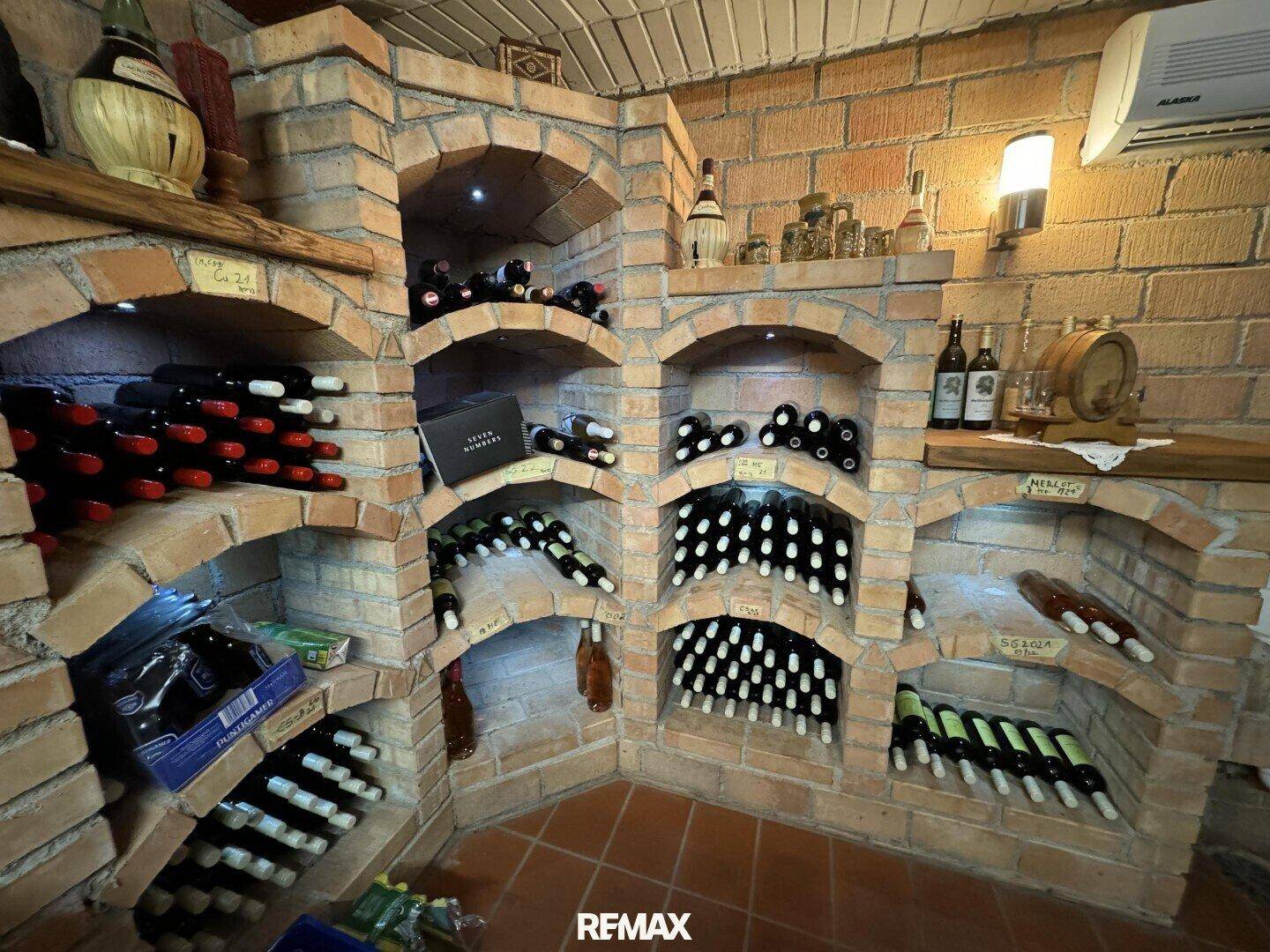 Detailansicht der gemauerten Weinregale, gefüllt mit Weinflaschen im Keller.
