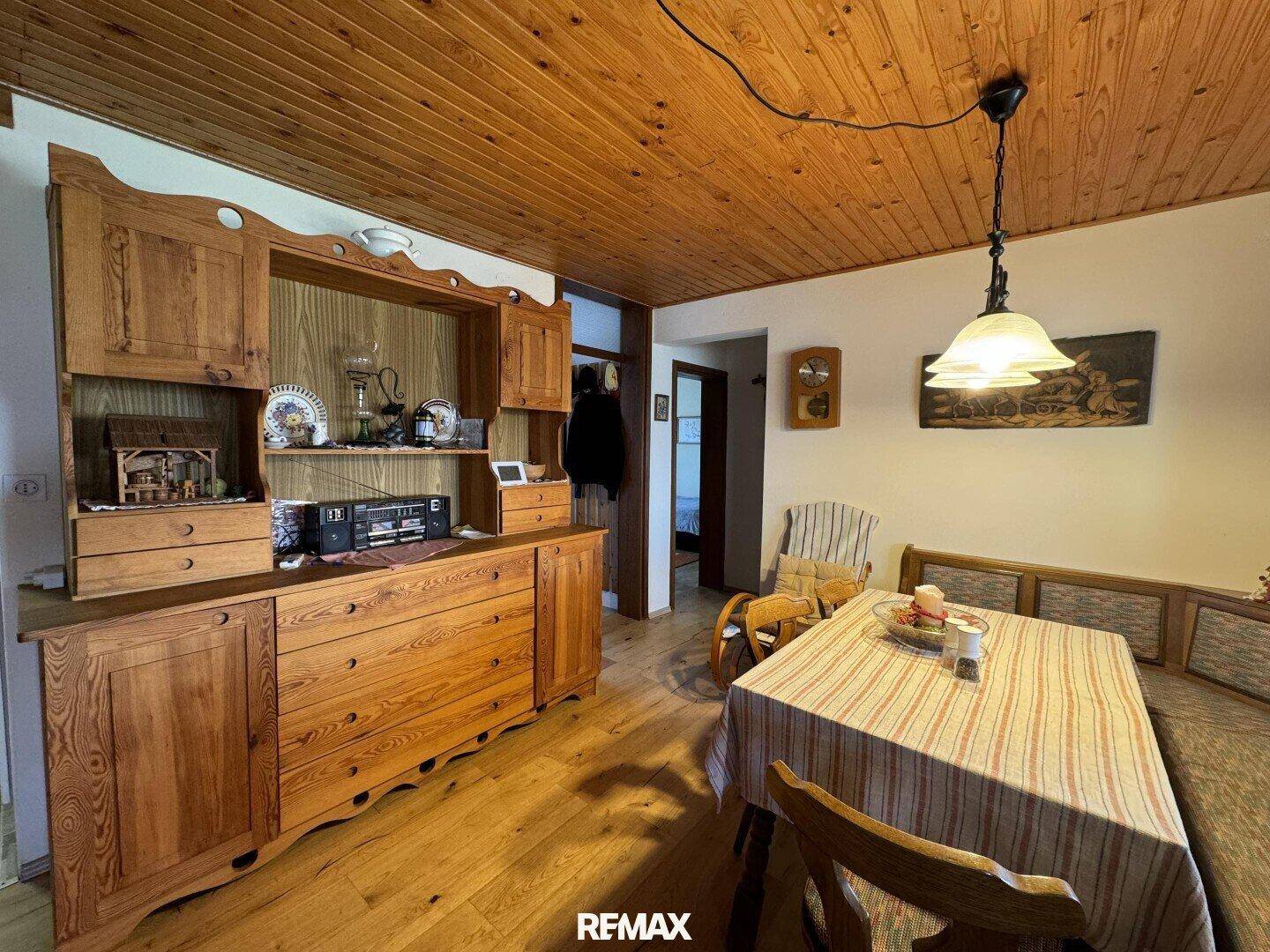 Rustikaler Essbereich mit Holzboden, Holzdecke und traditionellen Holzmöbeln.