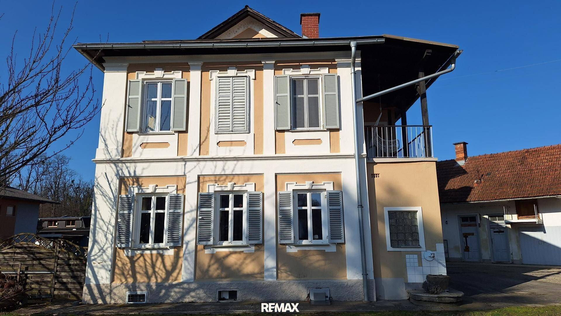 Seitenansicht des traditionellen Gebäudes mit Fensterläden und einem kleinen Balkon.