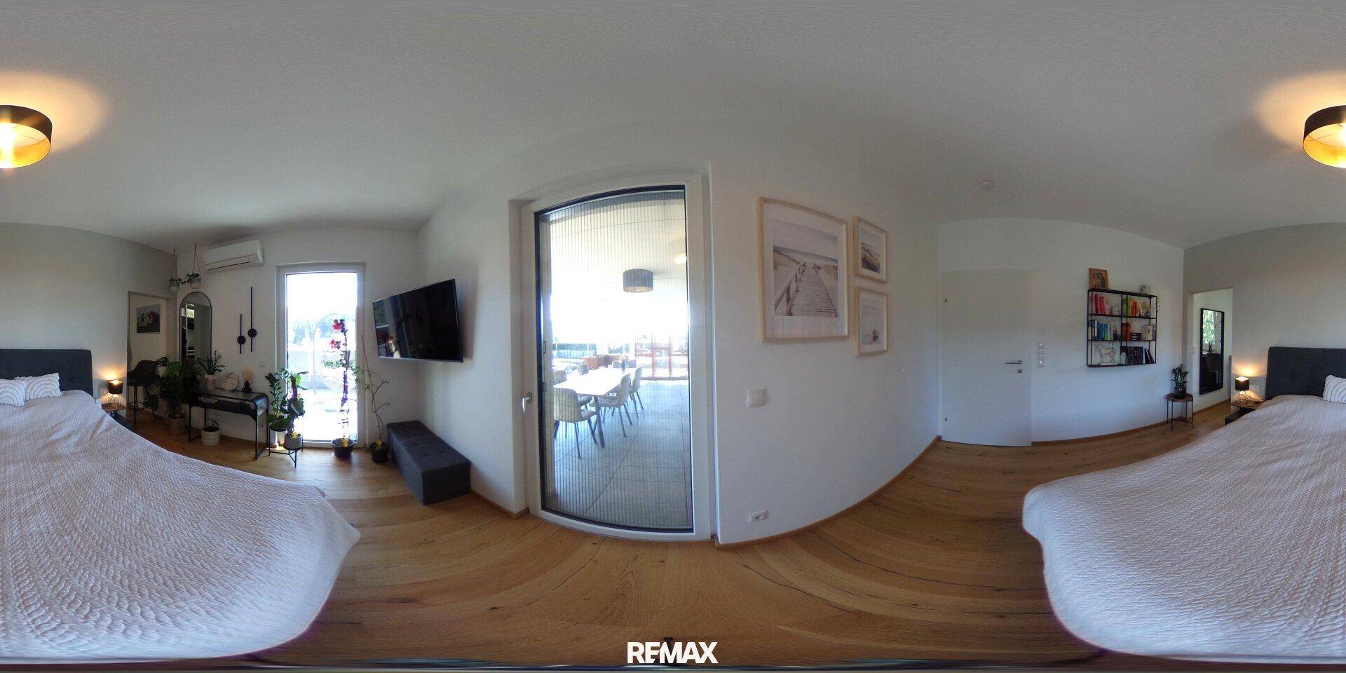 Helles Schlafzimmer mit Holzboden, großem Bett und direktem Zugang zu einer Außenterrasse.