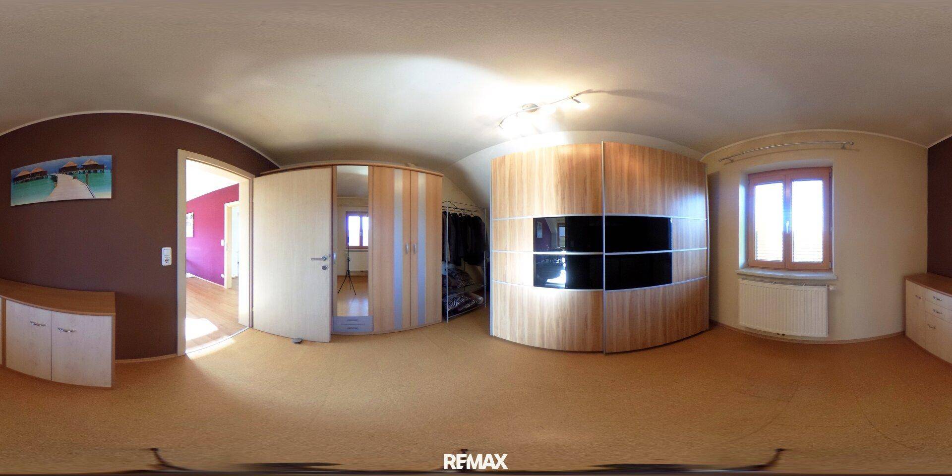 Schlafzimmer mit großen, holzfarbenen Einbauschränken und Teppichboden für viel Stauraum.