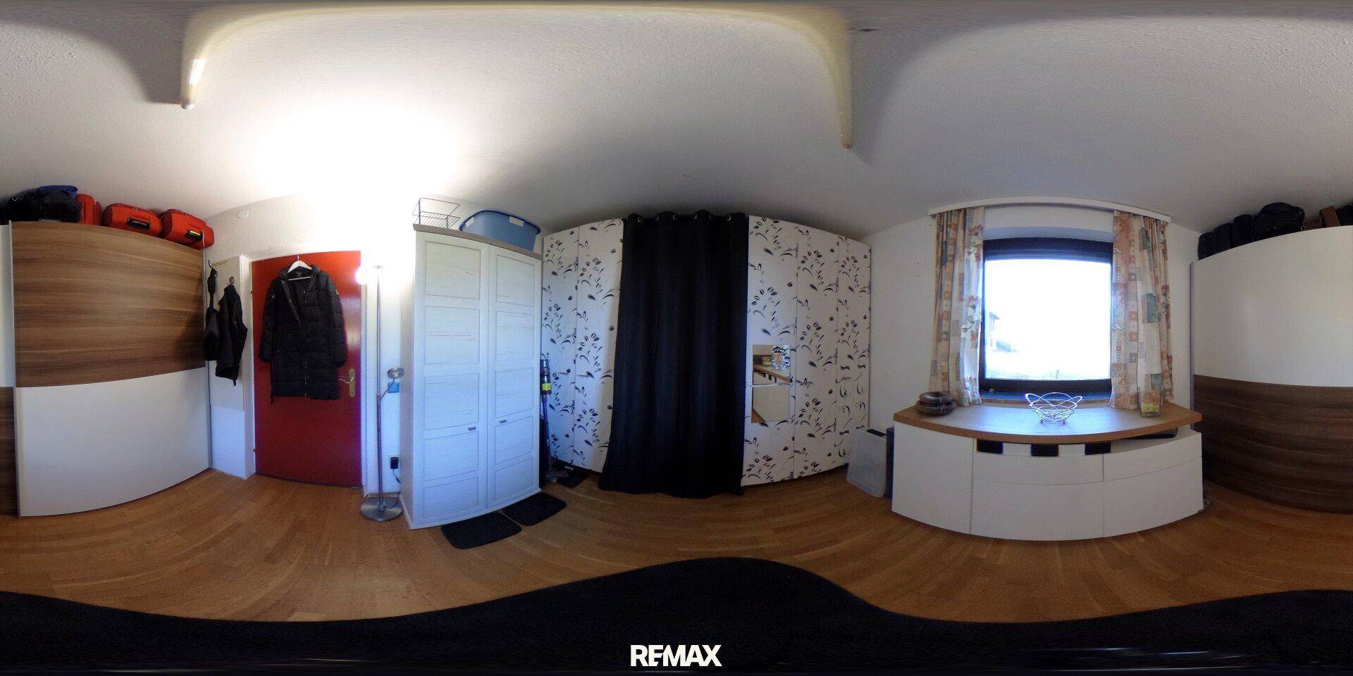Schlafzimmer mit Holzboden, Einbauschränken und natürlichem Lichteinfall.
