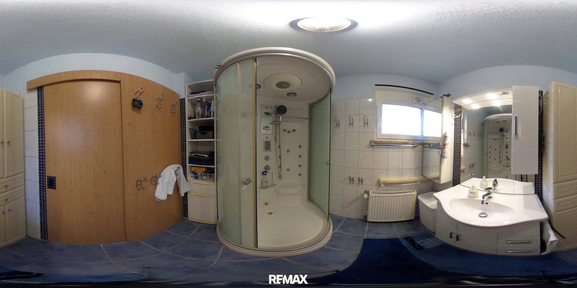 Modernes Badezimmer mit runder Duschkabine, Waschtisch und Fenster.