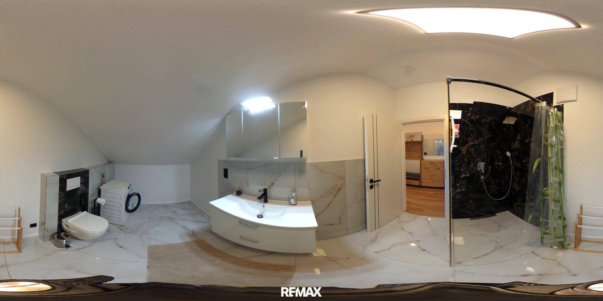 Modernes Badezimmer mit Dusche, WC und Waschbecken, ausgestattet mit eleganten Fliesen und Dachschräge.