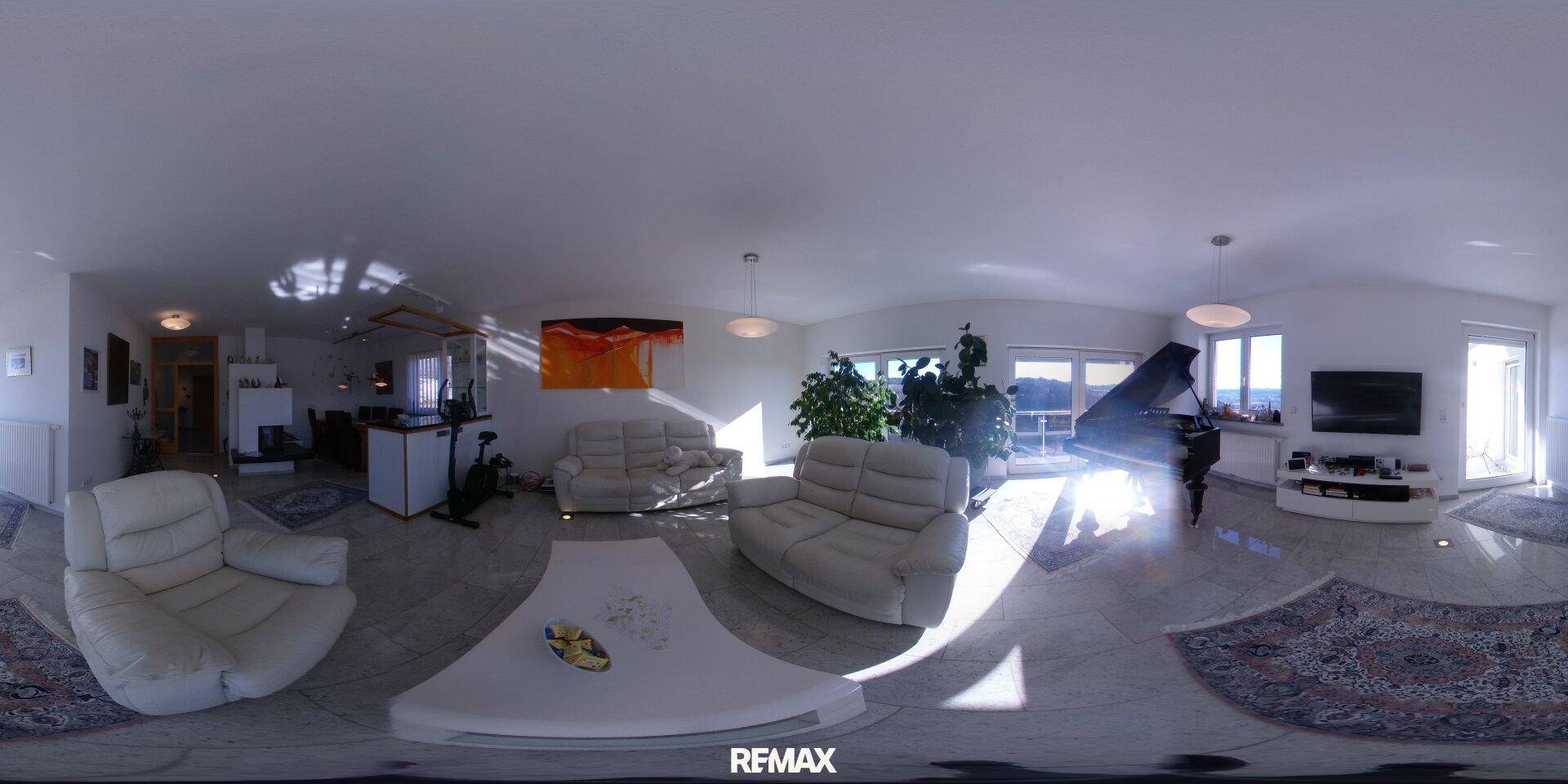 Geräumiges Wohnzimmer mit bequemen Sofas, Klavier und großen Fenstern, die viel Licht hereinlassen.