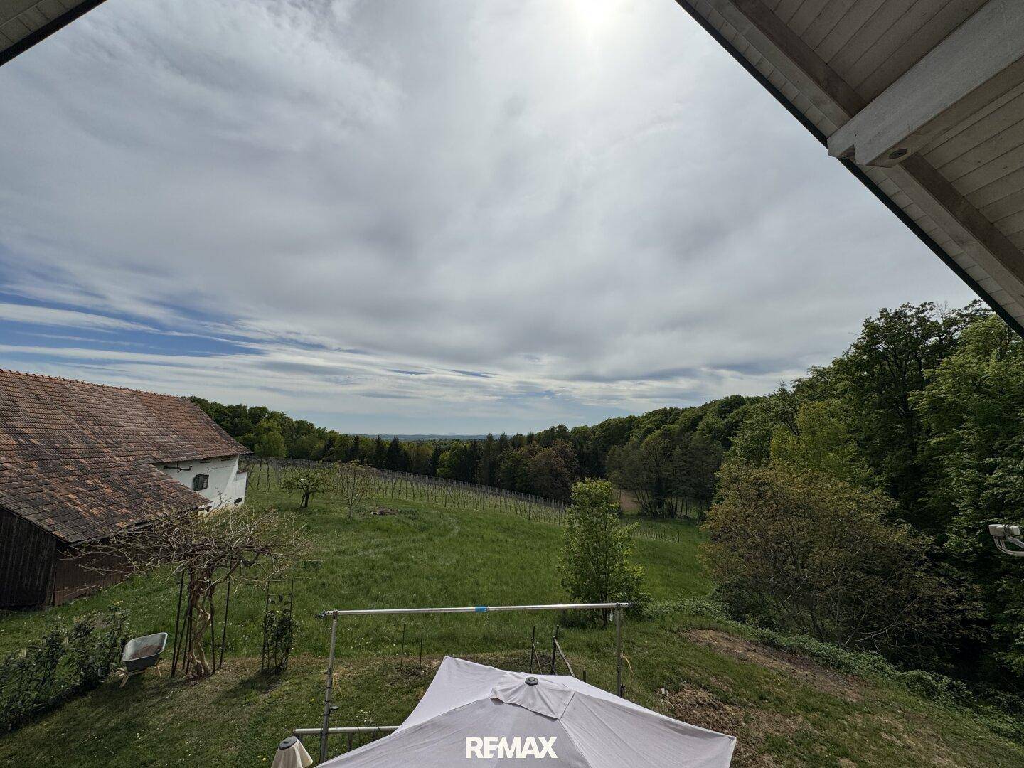Weitläufiger Blick über grüne Hügel und Weinberge von einer erhöhten Terrasse.