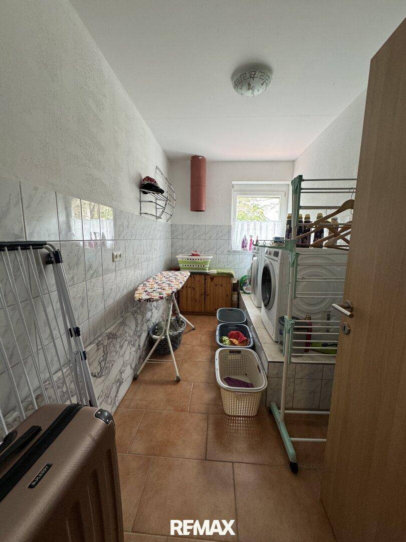 Praktischer Hauswirtschaftsraum mit Waschmaschine, Trockner und viel Platz zum Wäschewaschen.
