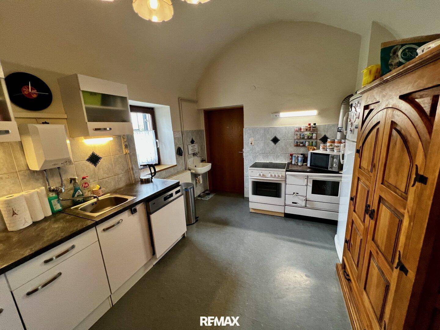 Küche mit gewölbter Decke, Fliesenboden und traditionellen Einbaumöbeln.