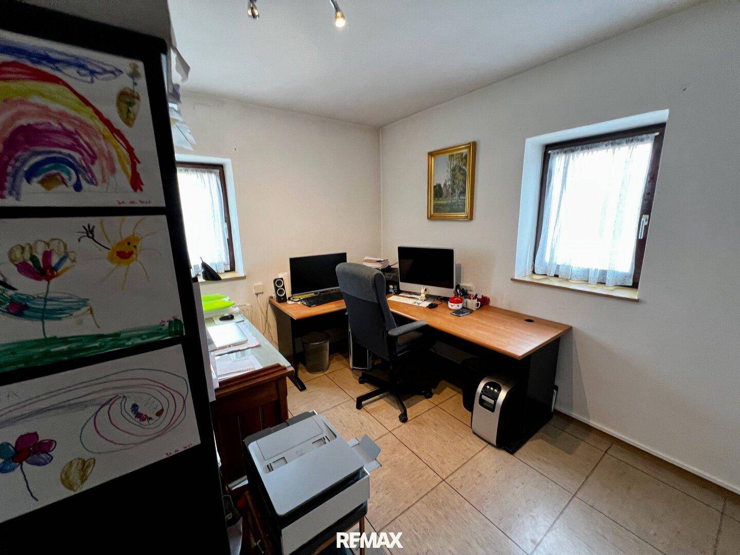 Arbeitszimmer mit zwei Schreibtischen, Fliesenboden und natürlichem Lichteinfall.