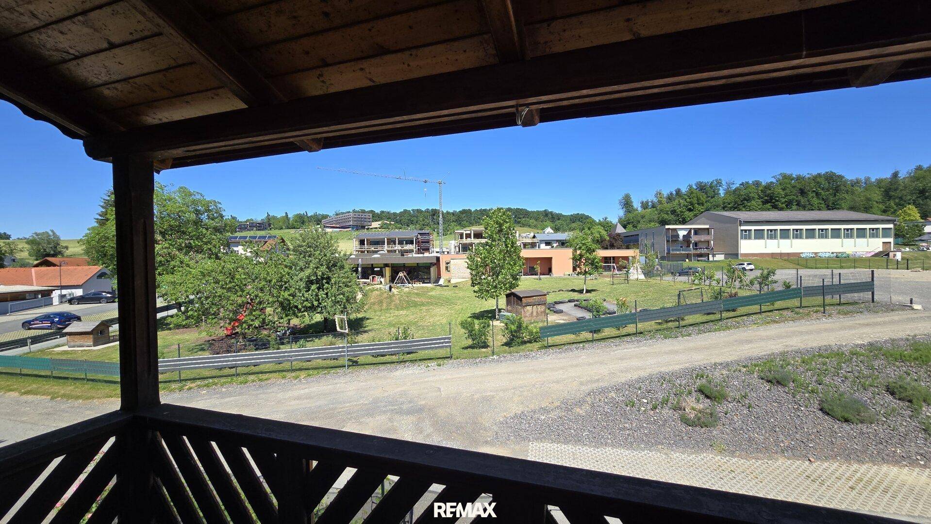 Ausblick vom Balkon auf die umliegende Landschaft und weitere Gebäude in der Ferne.