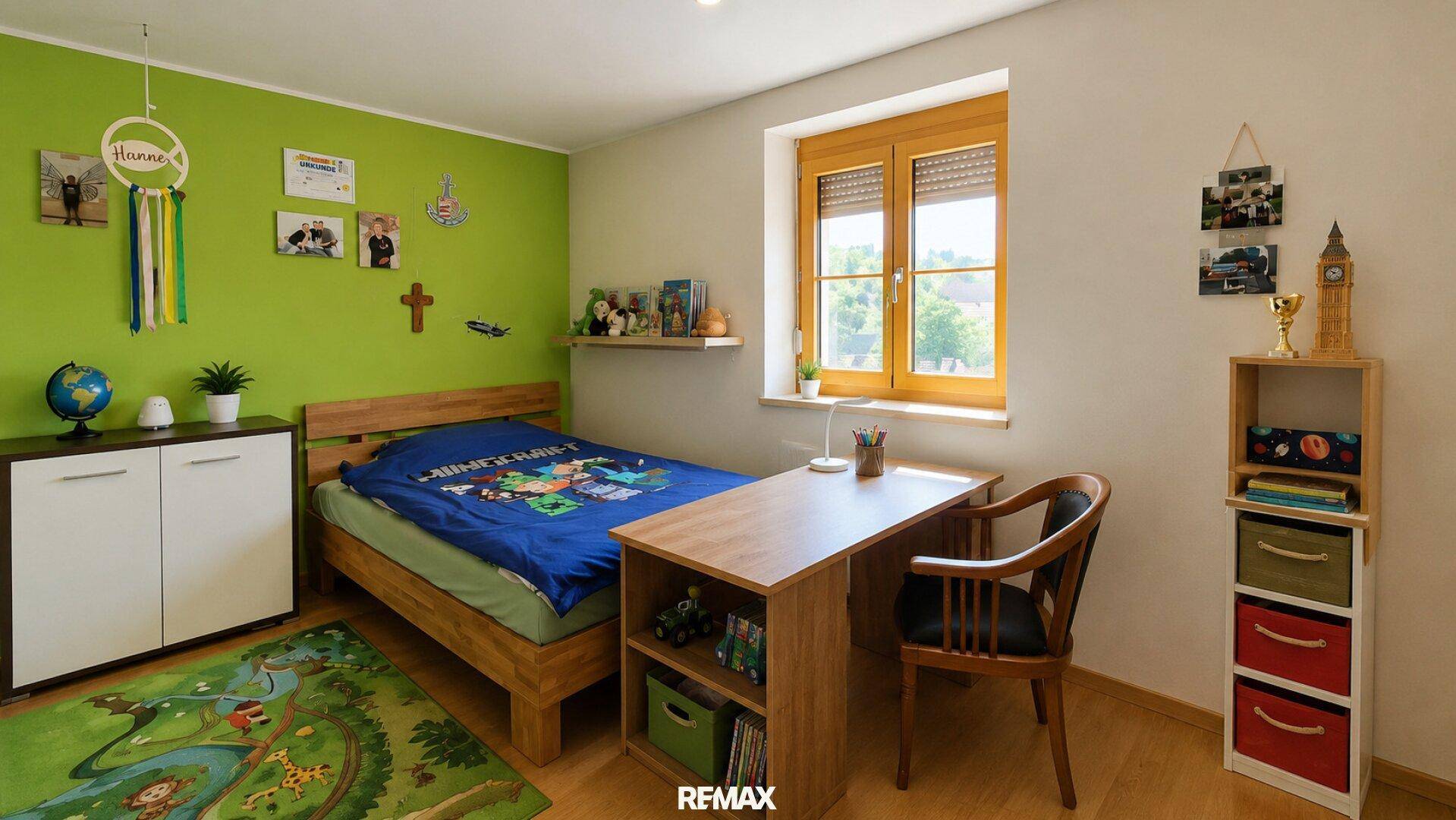 Freundliches Kinderzimmer mit grün gestrichener Wand, Holzbett und Schreibtisch am Fenster.