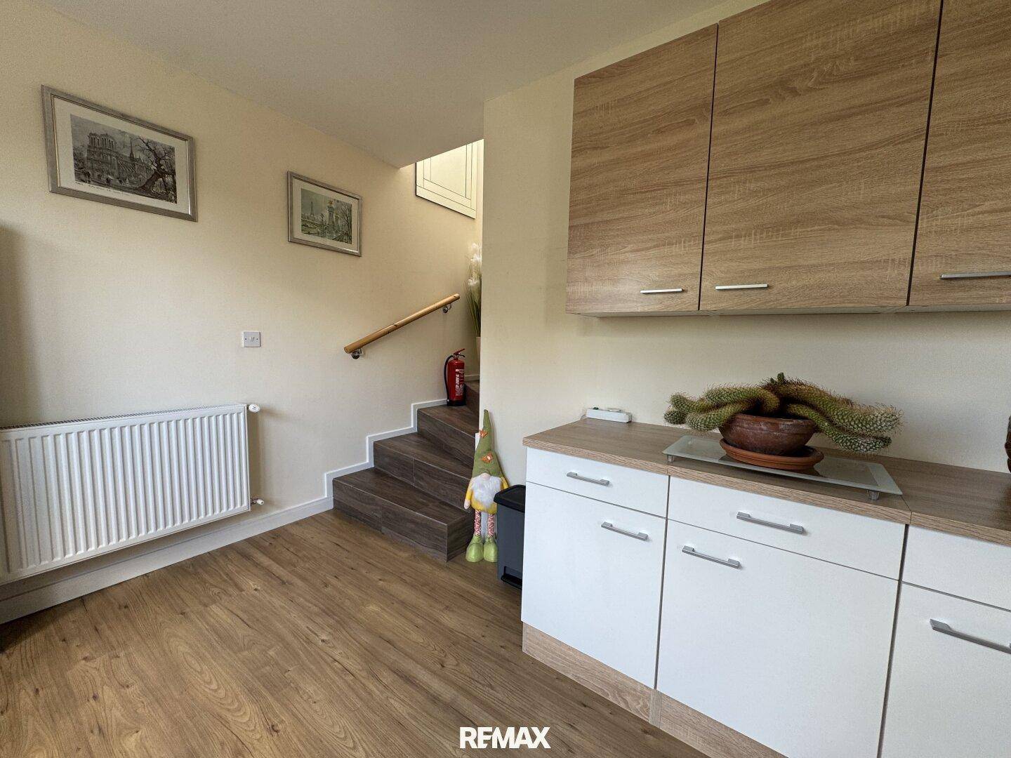 Heller Flur mit Laminatboden, Treppe und praktischen Einbauschränken für zusätzlichen Stauraum.