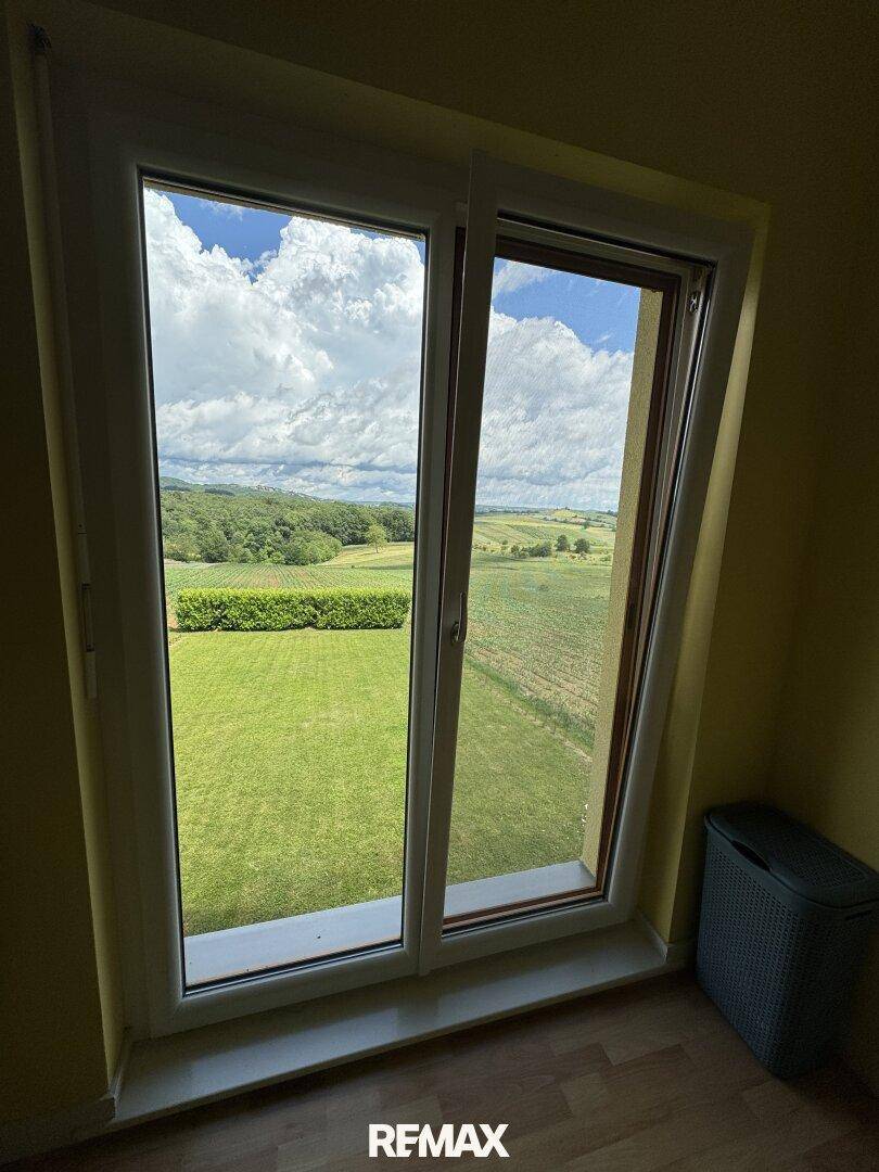 Große Fenster bieten einen weiten Blick auf die grüne Landschaft und die umliegenden Felder.