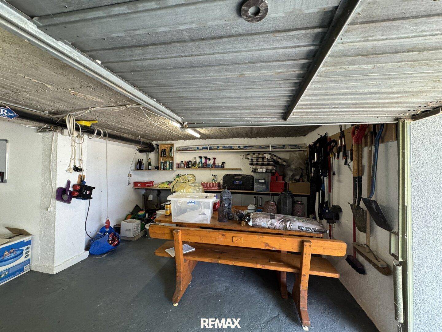 Geräumige Garage oder Werkstatt mit viel Stauraum, einer stabilen Werkbank und verschiedenen Werkzeugen.