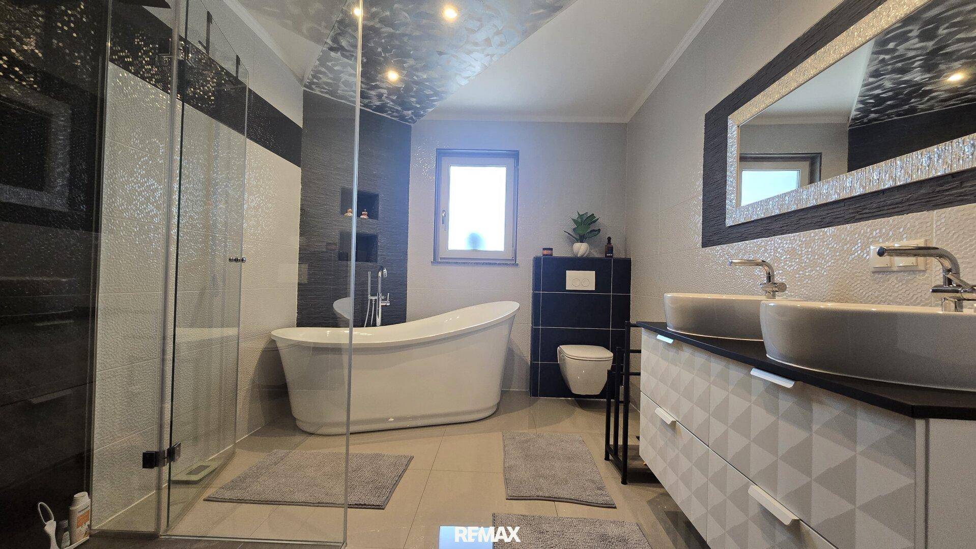 Modernes Badezimmer mit freistehender Badewanne, großer Dusche und Doppelwaschbecken.