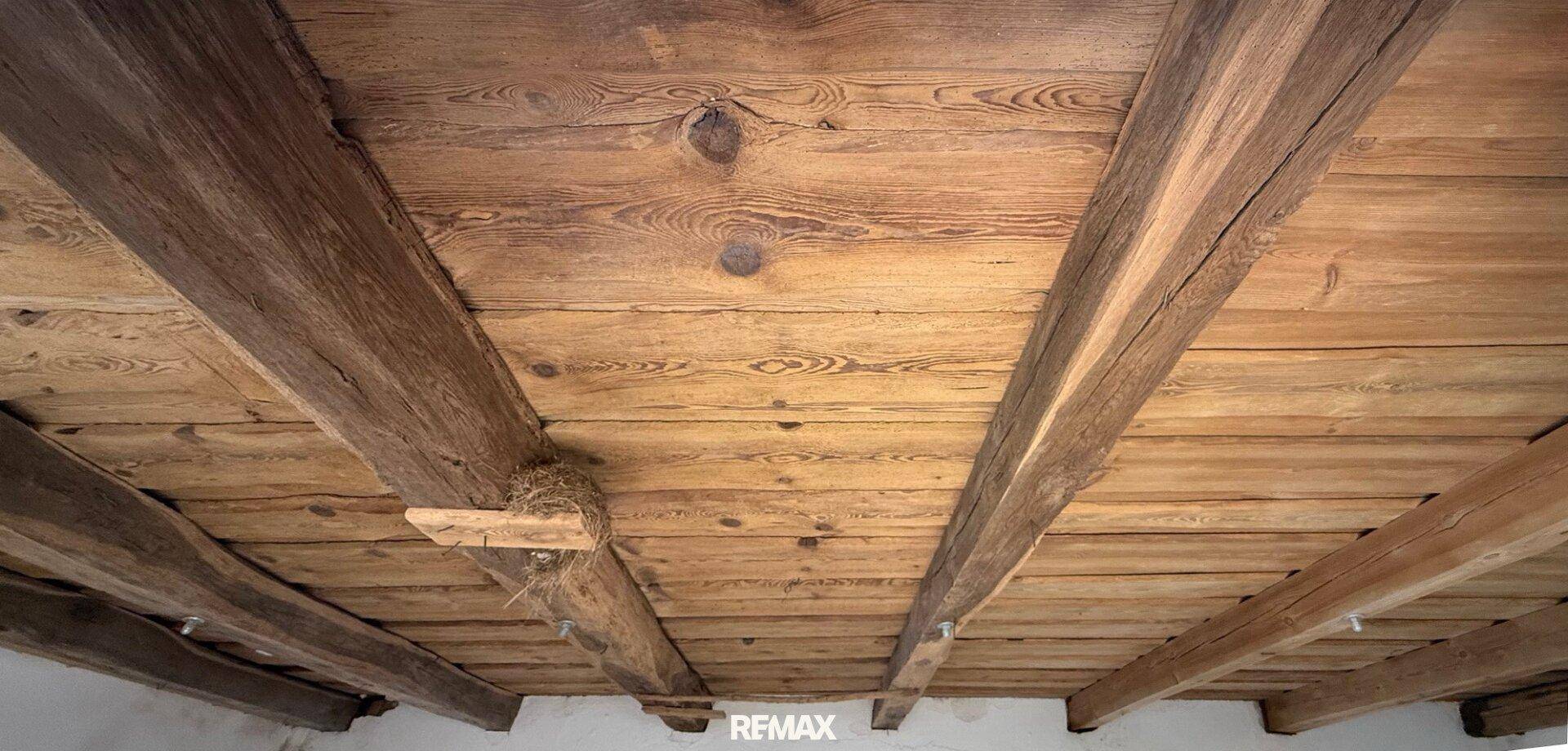 Rustikale Holzdecke mit sichtbaren Balken und Holzbrettern.